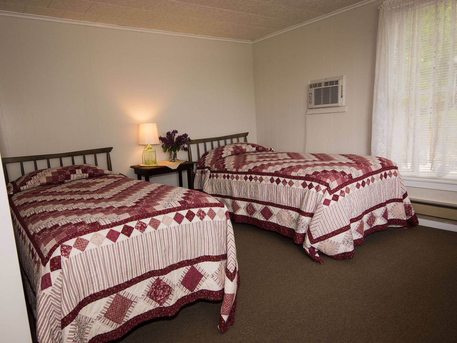 A bedroom with two beds and a window