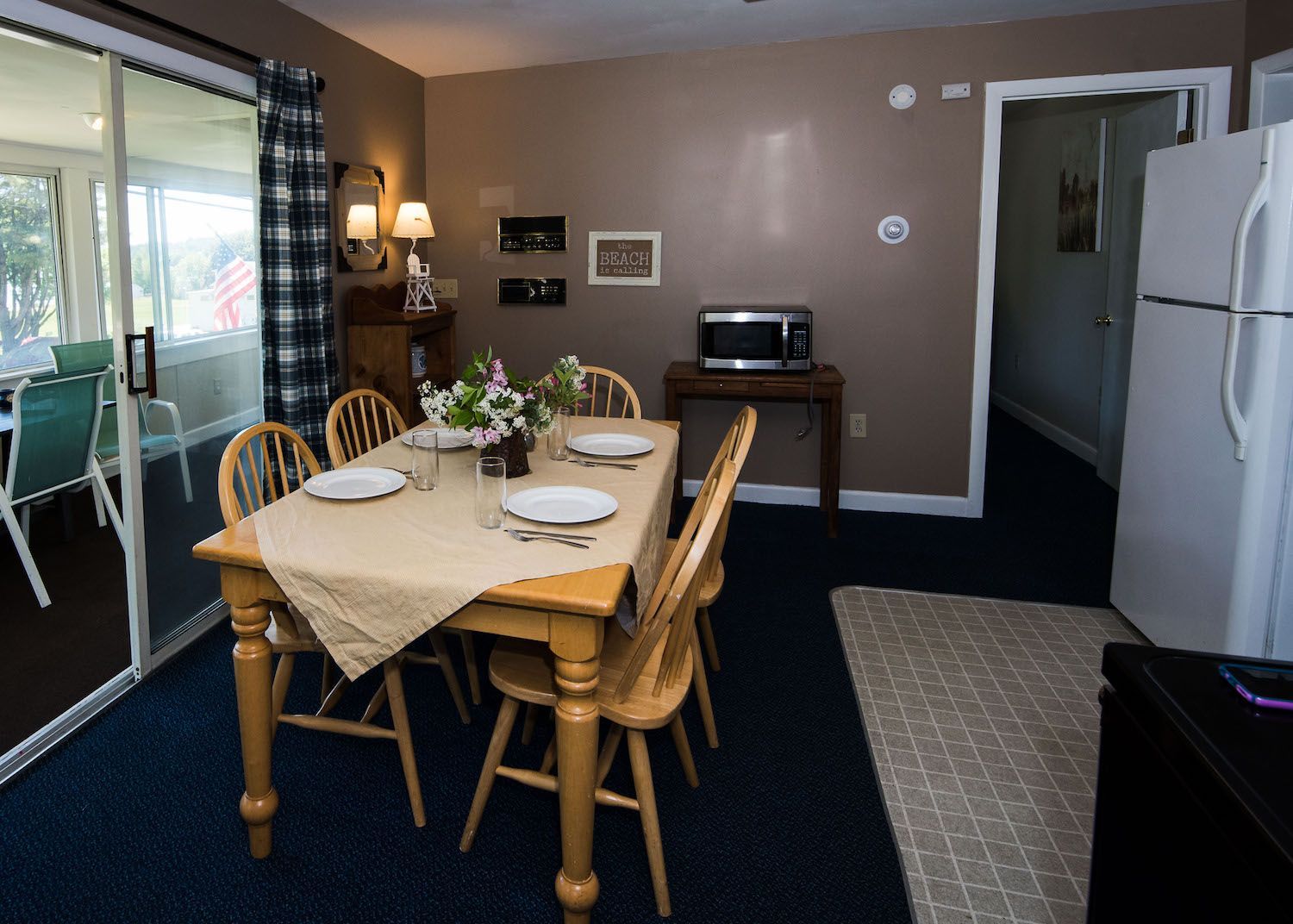 A dining room with a table and chairs and a refrigerator