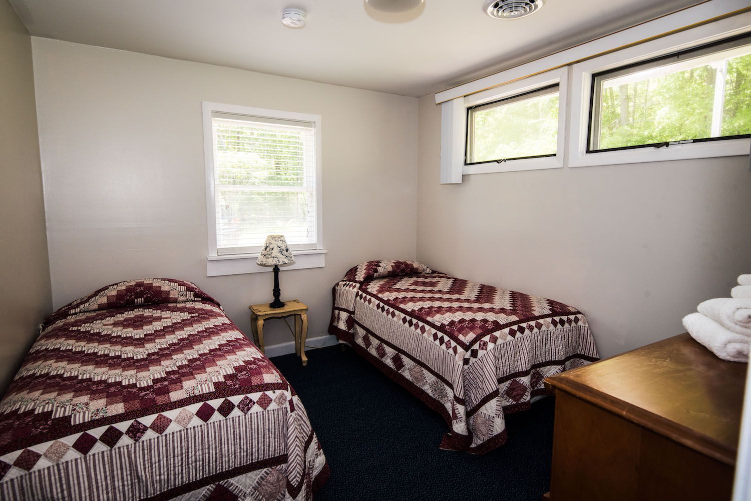 A bedroom with two beds and a lamp