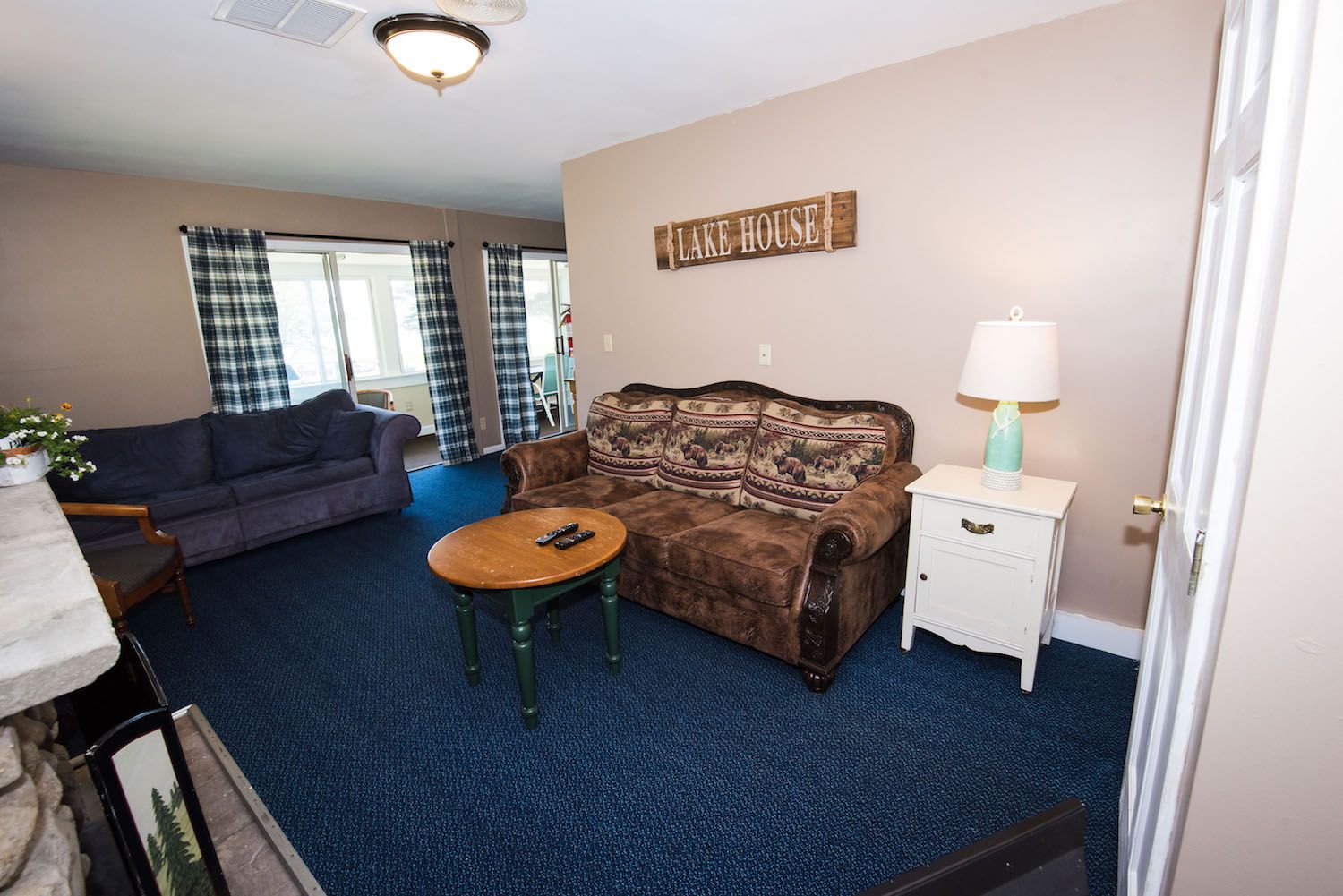 A living room with a couch and a table and a sign on the wall that says ' coors '