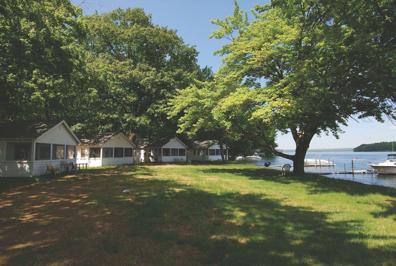 A row of white houses sit next to a body of water