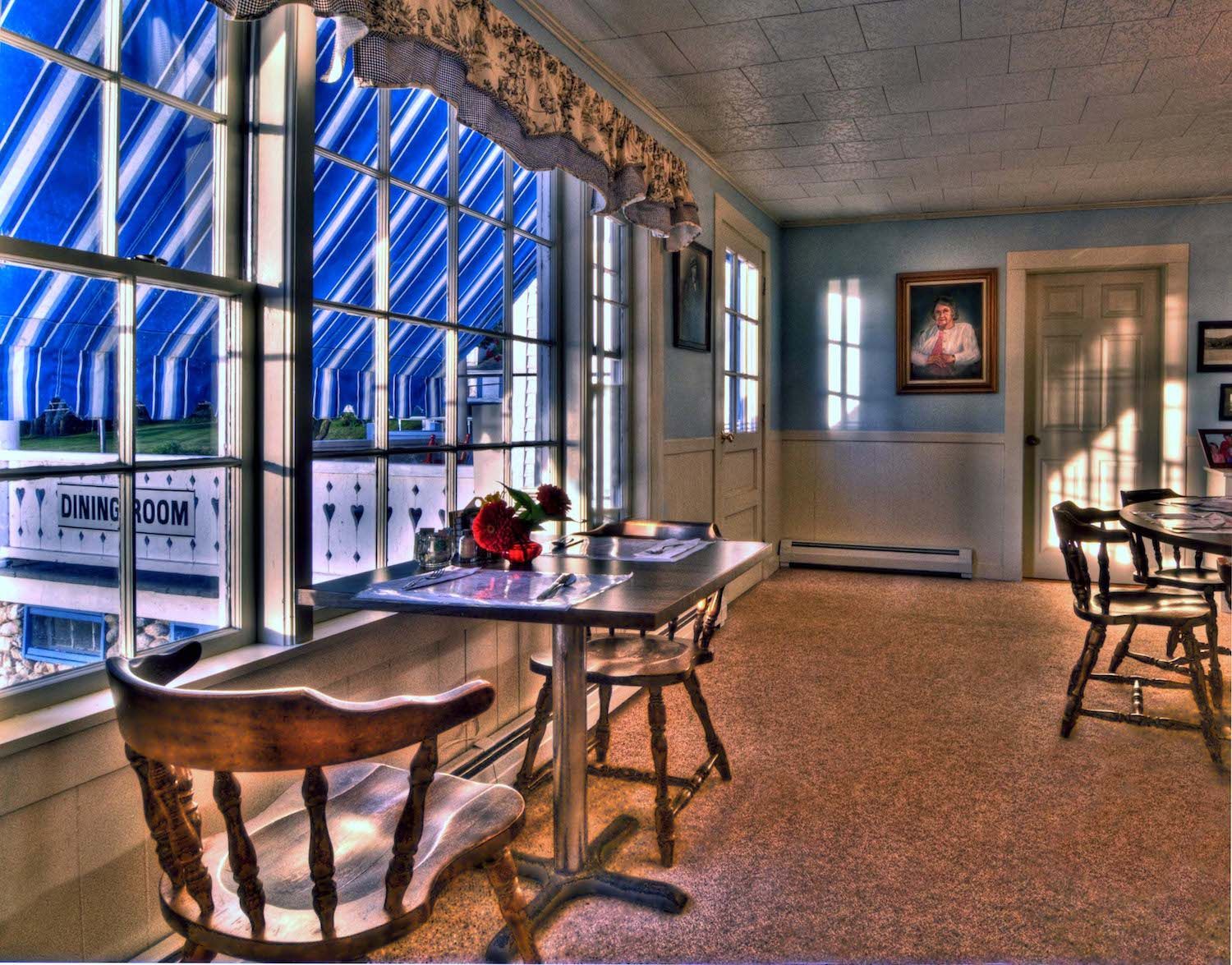 A room with a table and chairs and a sign that says living room