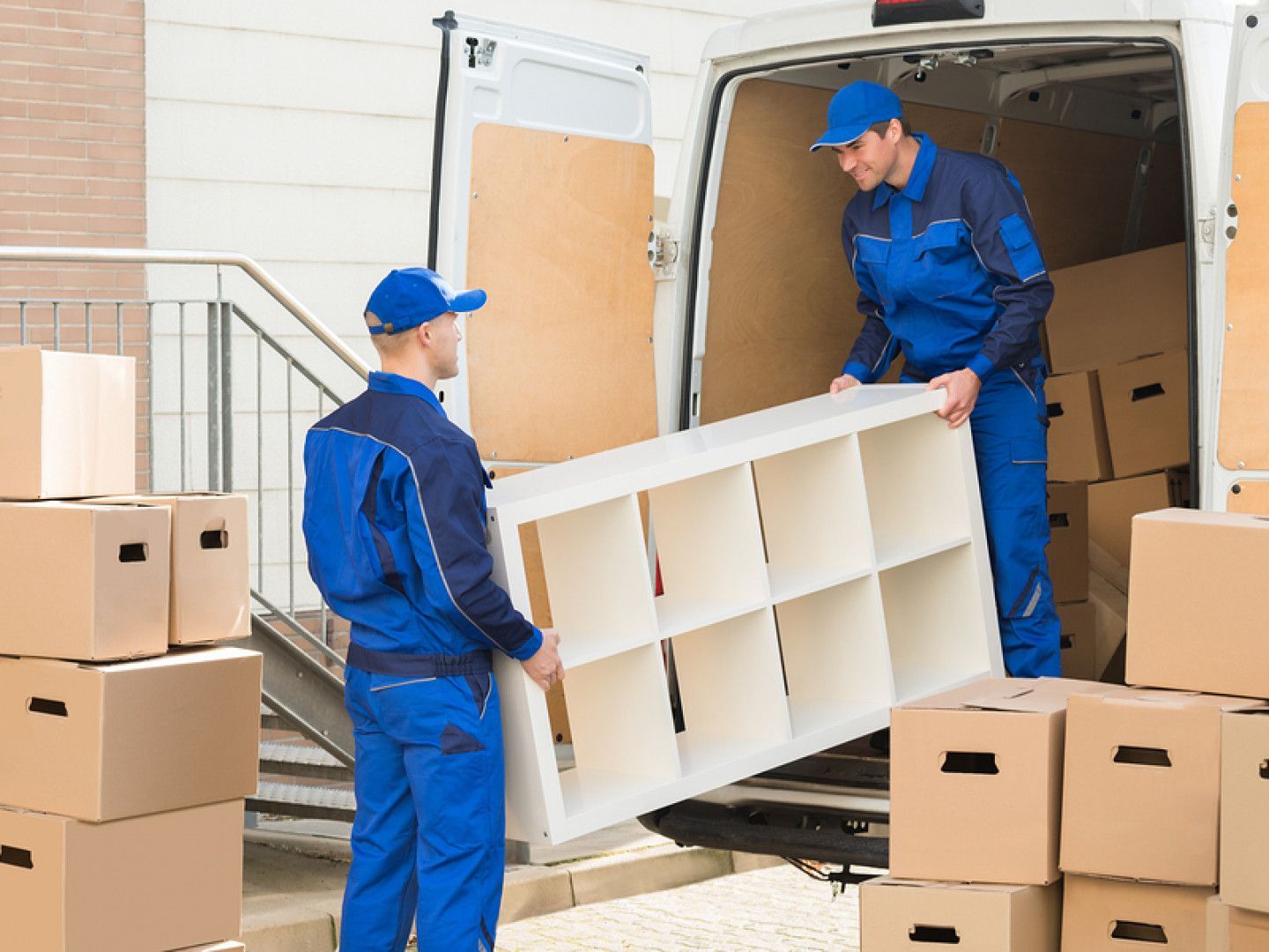 two men are loading a shelf into a van