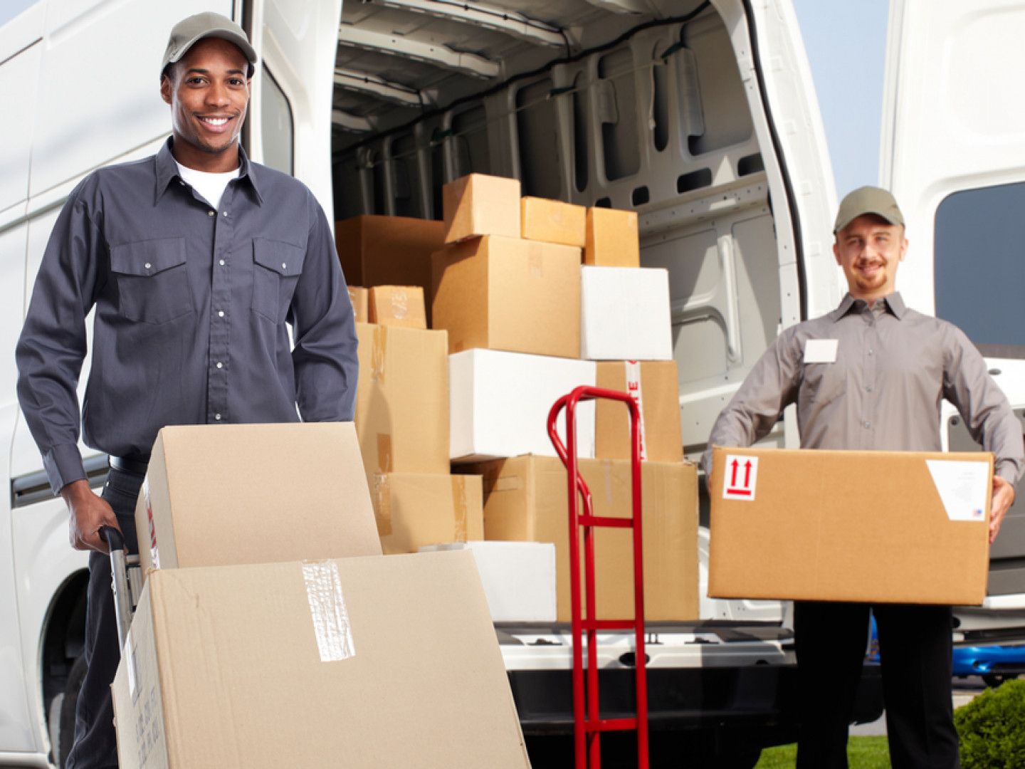 two delivery men are loading boxes into a van