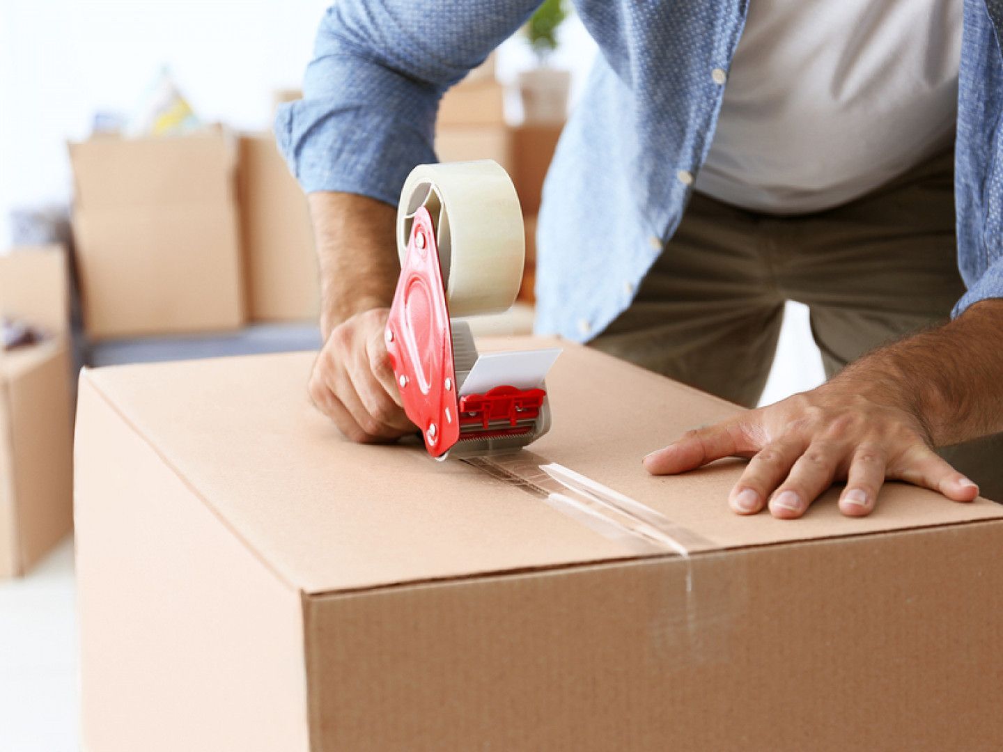 a man is taping a cardboard box with tape