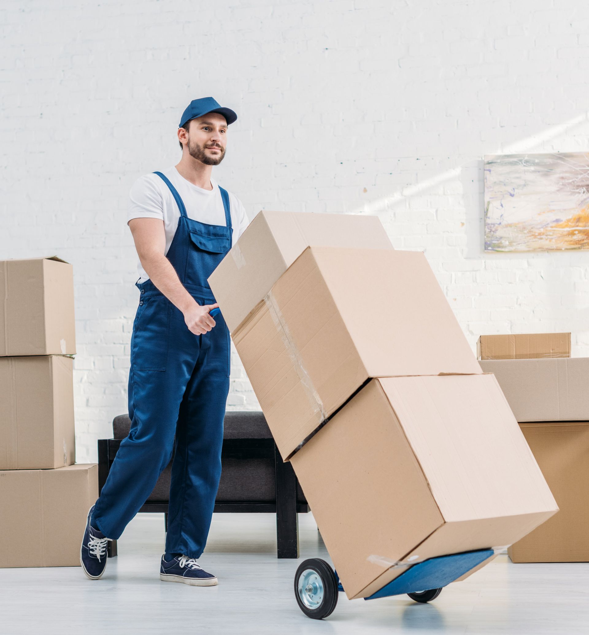 a man is pushing a cart full of cardboard boxes