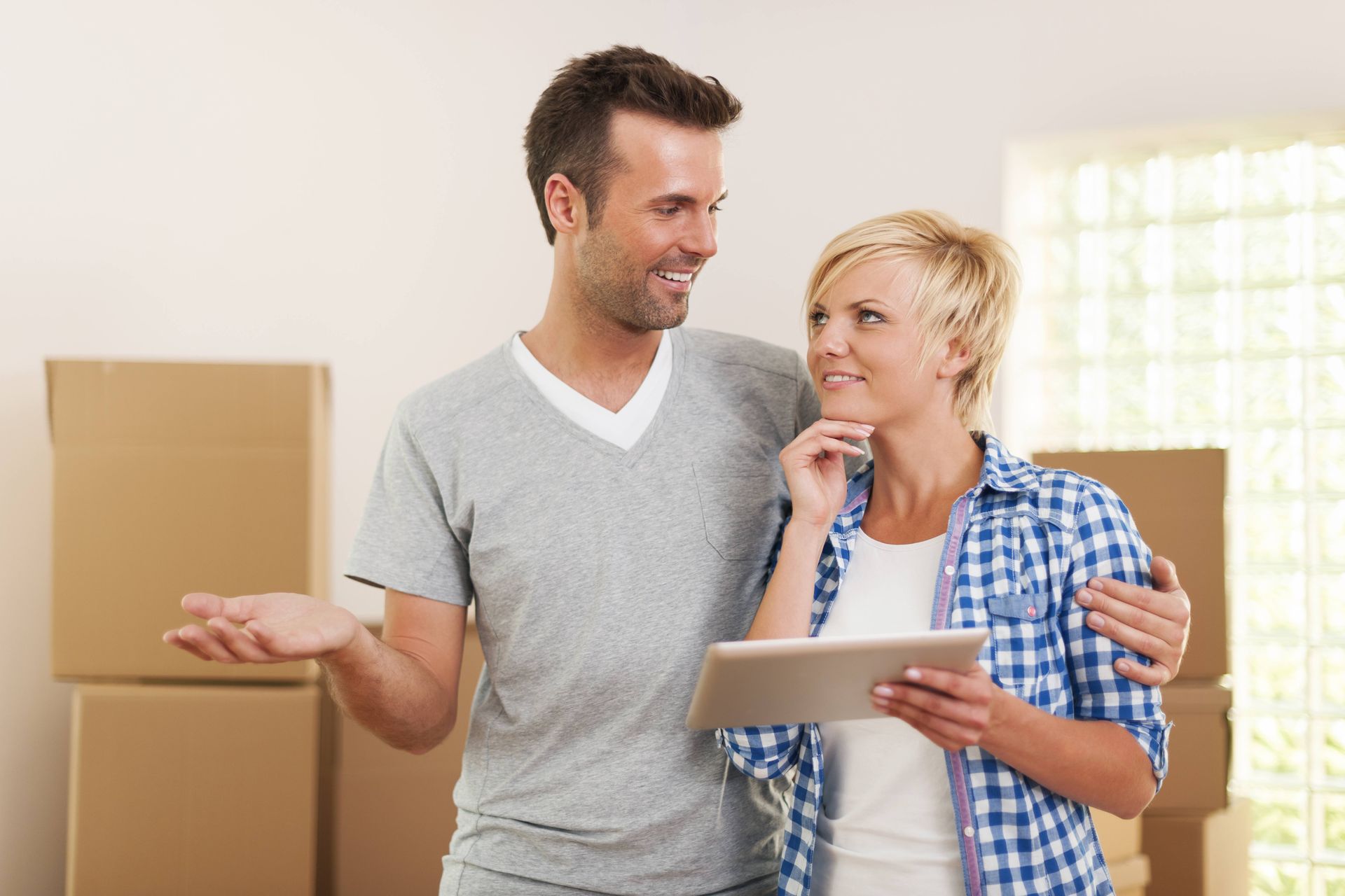 a man and a woman are standing next to each other looking at a tablet