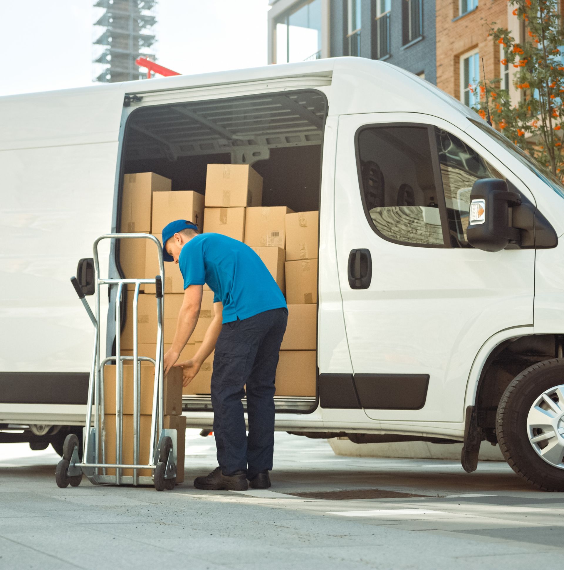 a man is loading boxes into a white van