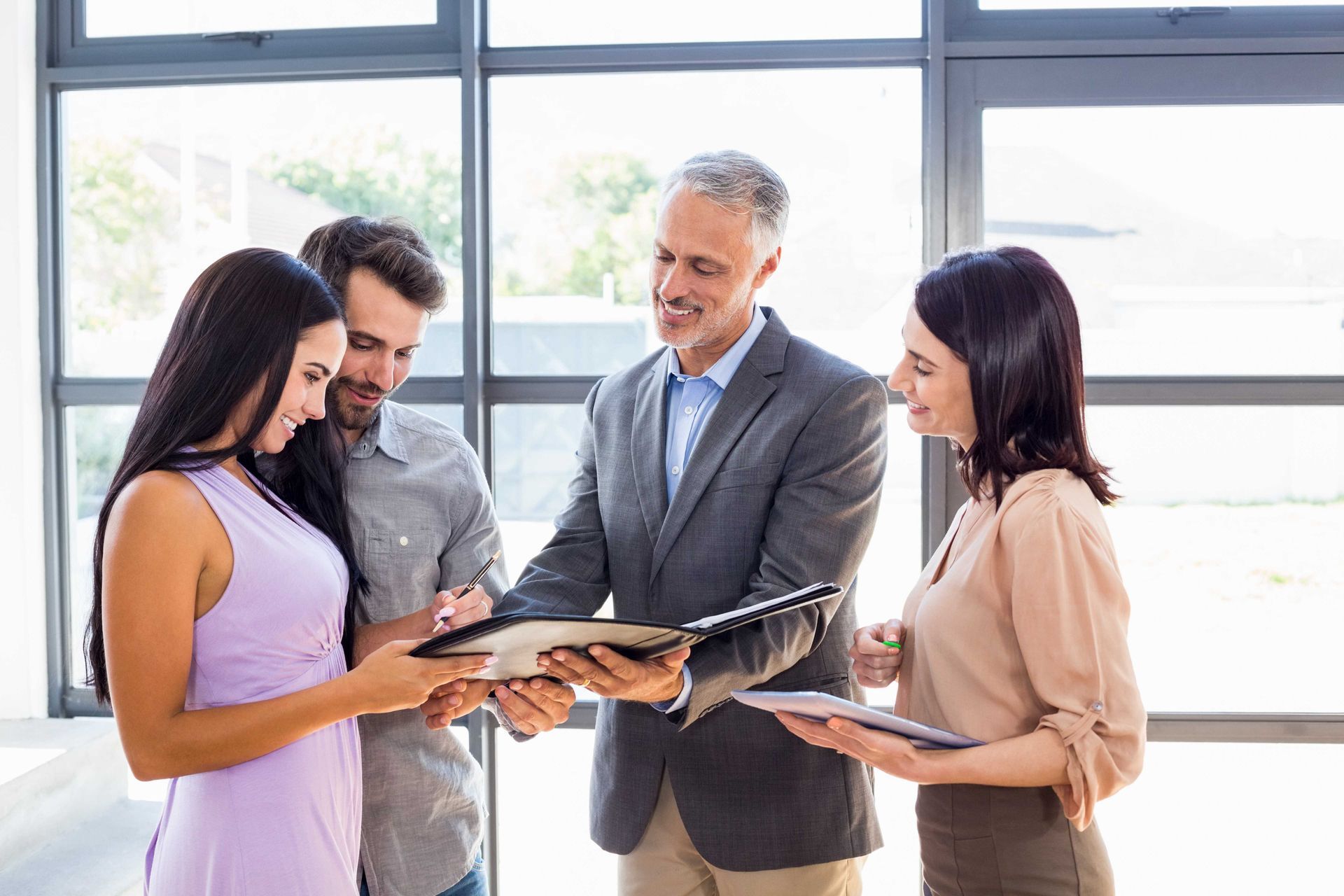 a group of people are standing around looking at a clipboard