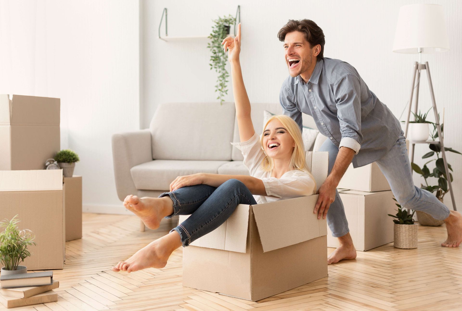 a man and a woman are playing with cardboard boxes in a living room