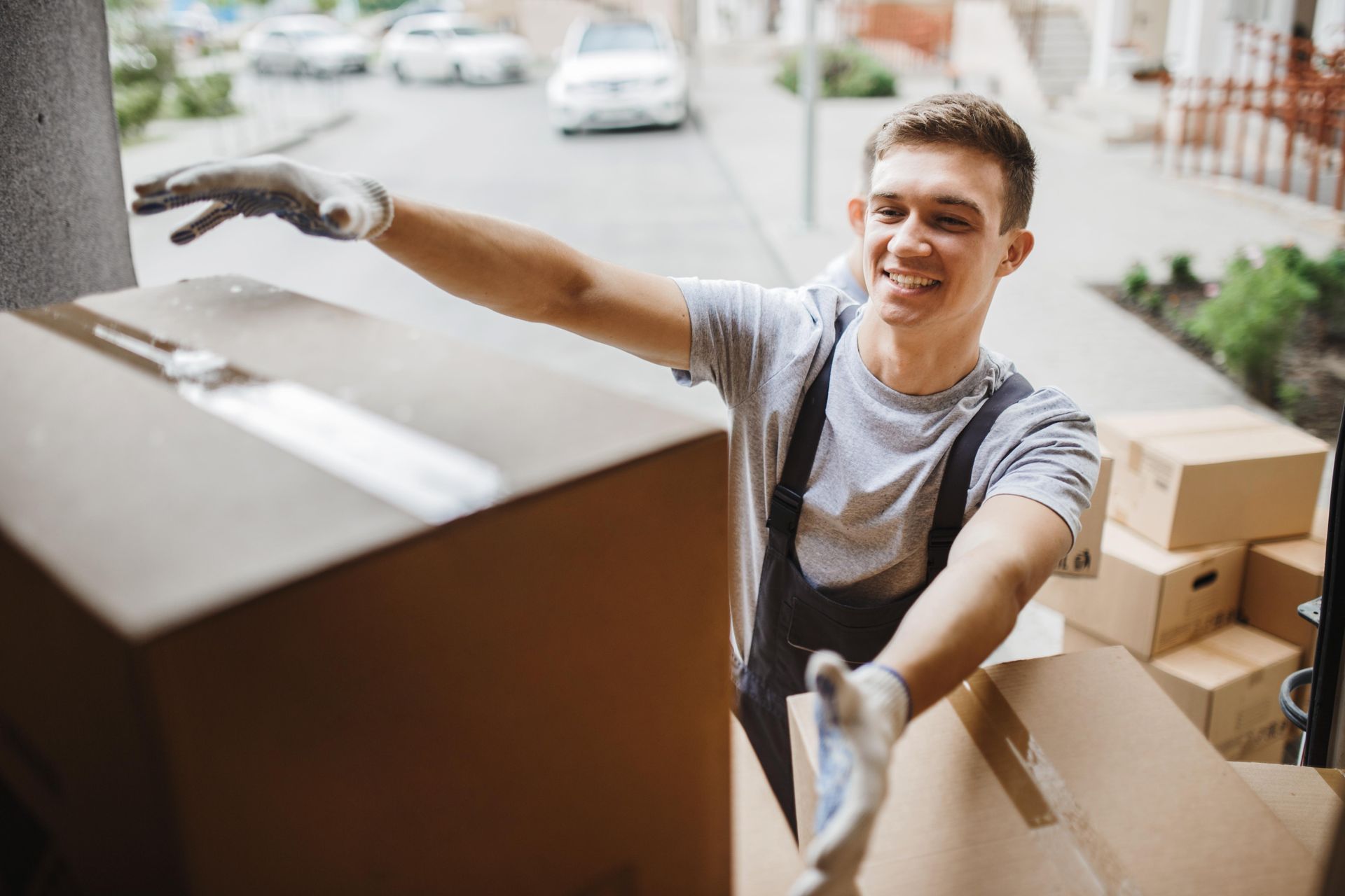 a man is holding a cardboard box with his arms outstretched