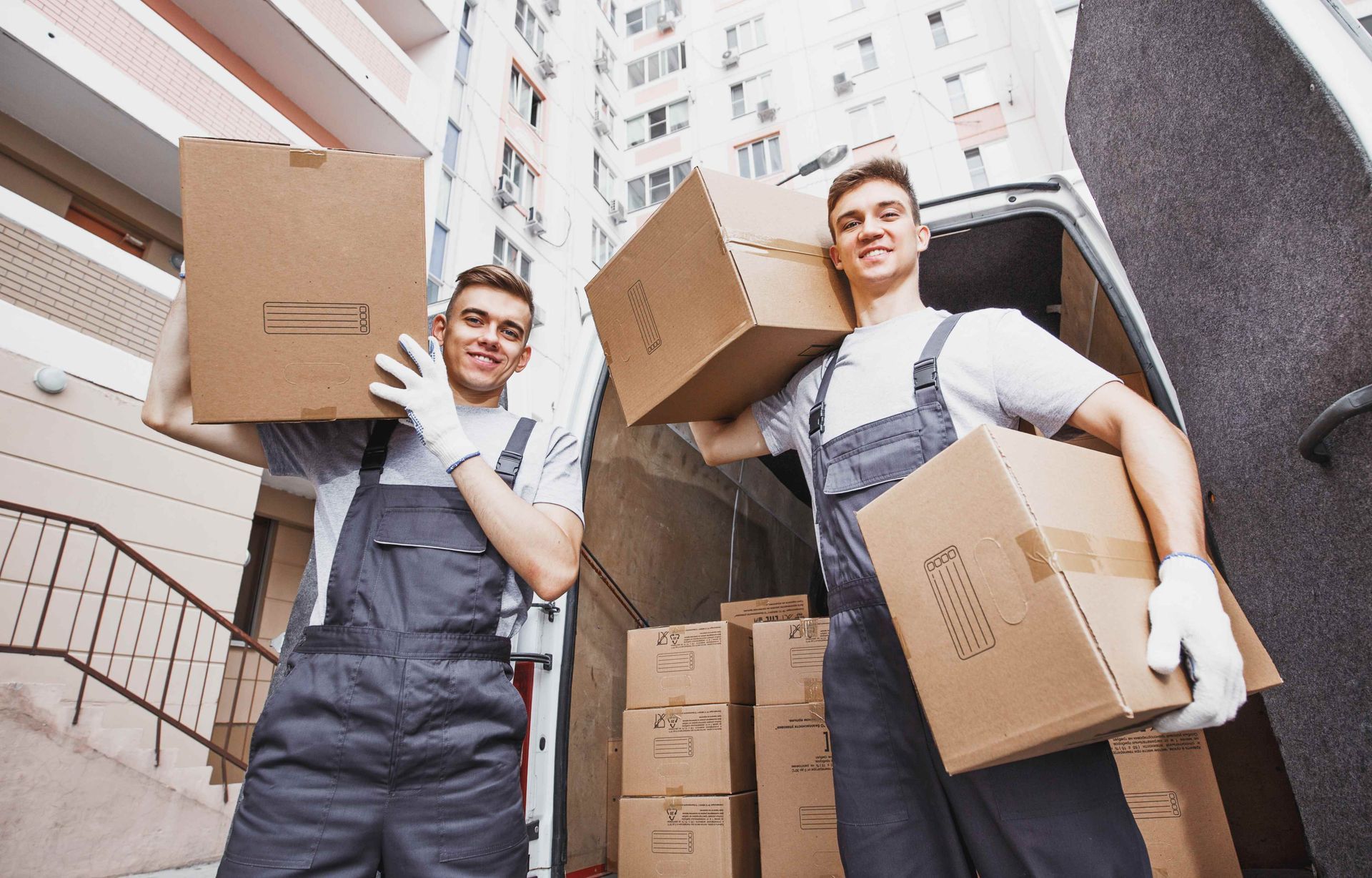 two men are carrying boxes out of a van