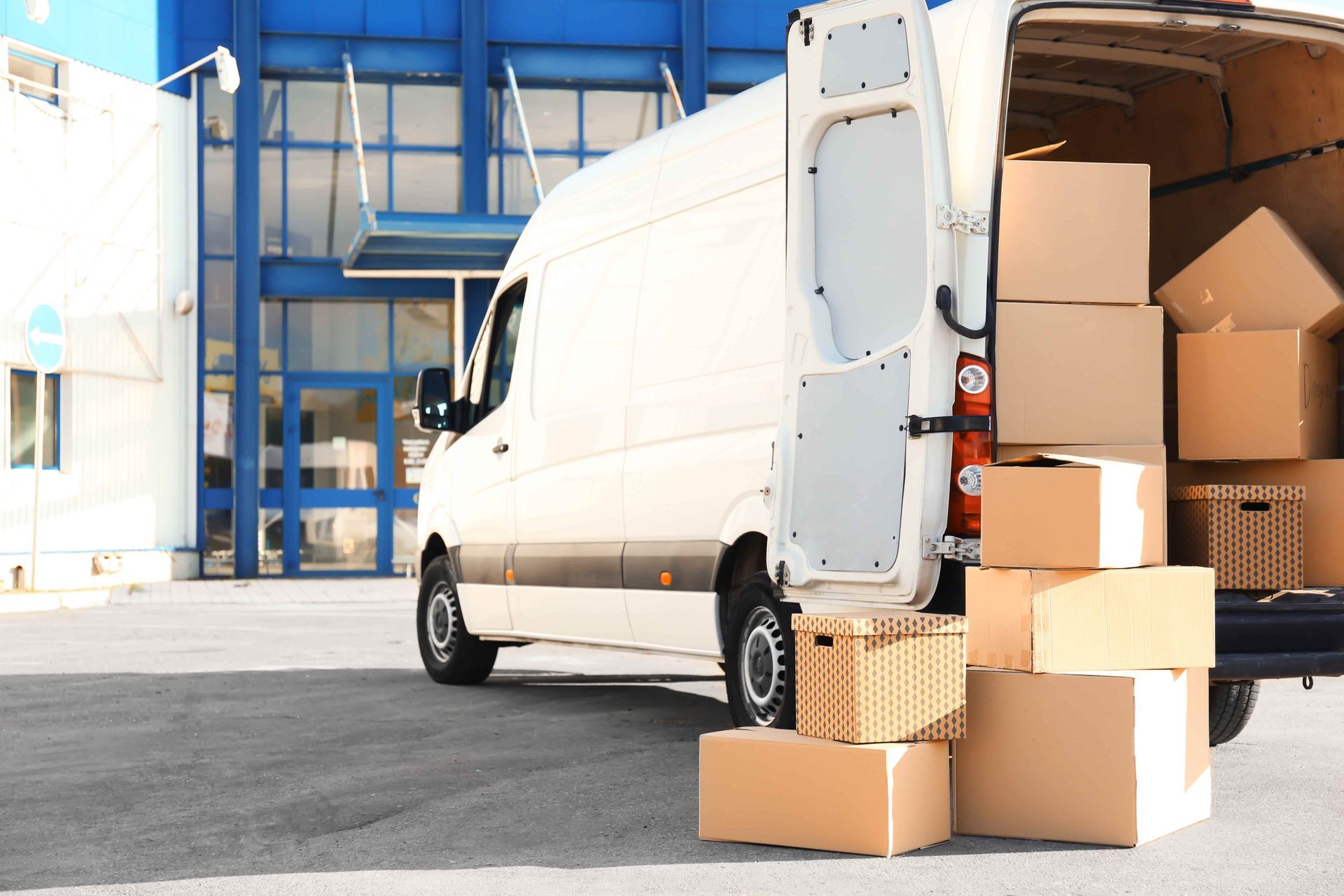 a white van is loaded with cardboard boxes in front of a building