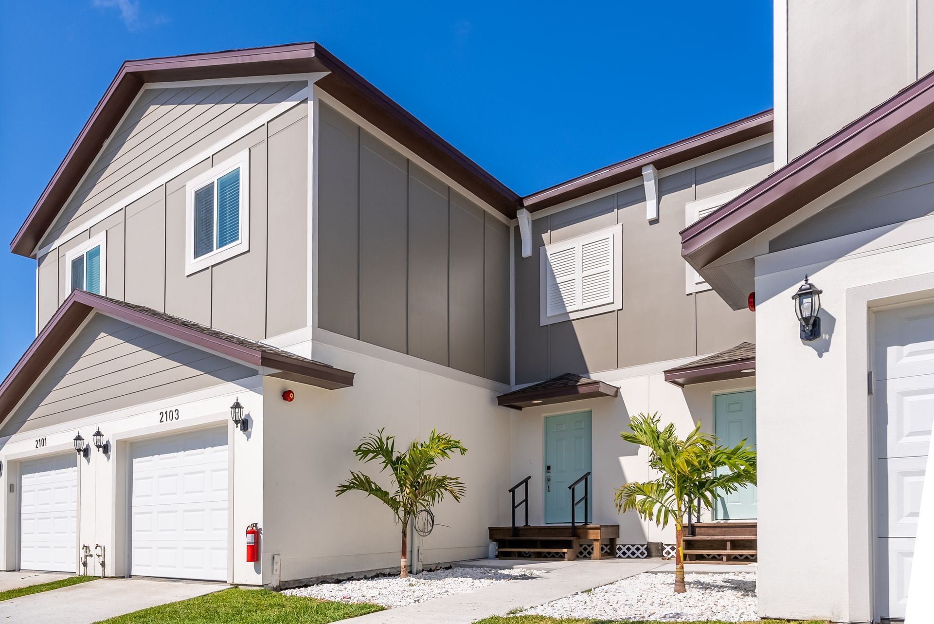 a white apartment building with two garages and a fire hydrant in front of it at Whitney Place Apartments in Clearwater, FL.