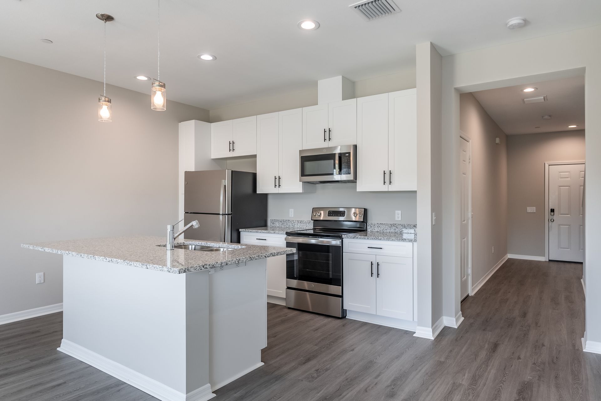 a kitchen with white cabinets and stainless steel appliances at Whitney Place Apartments in Clearwater, FL