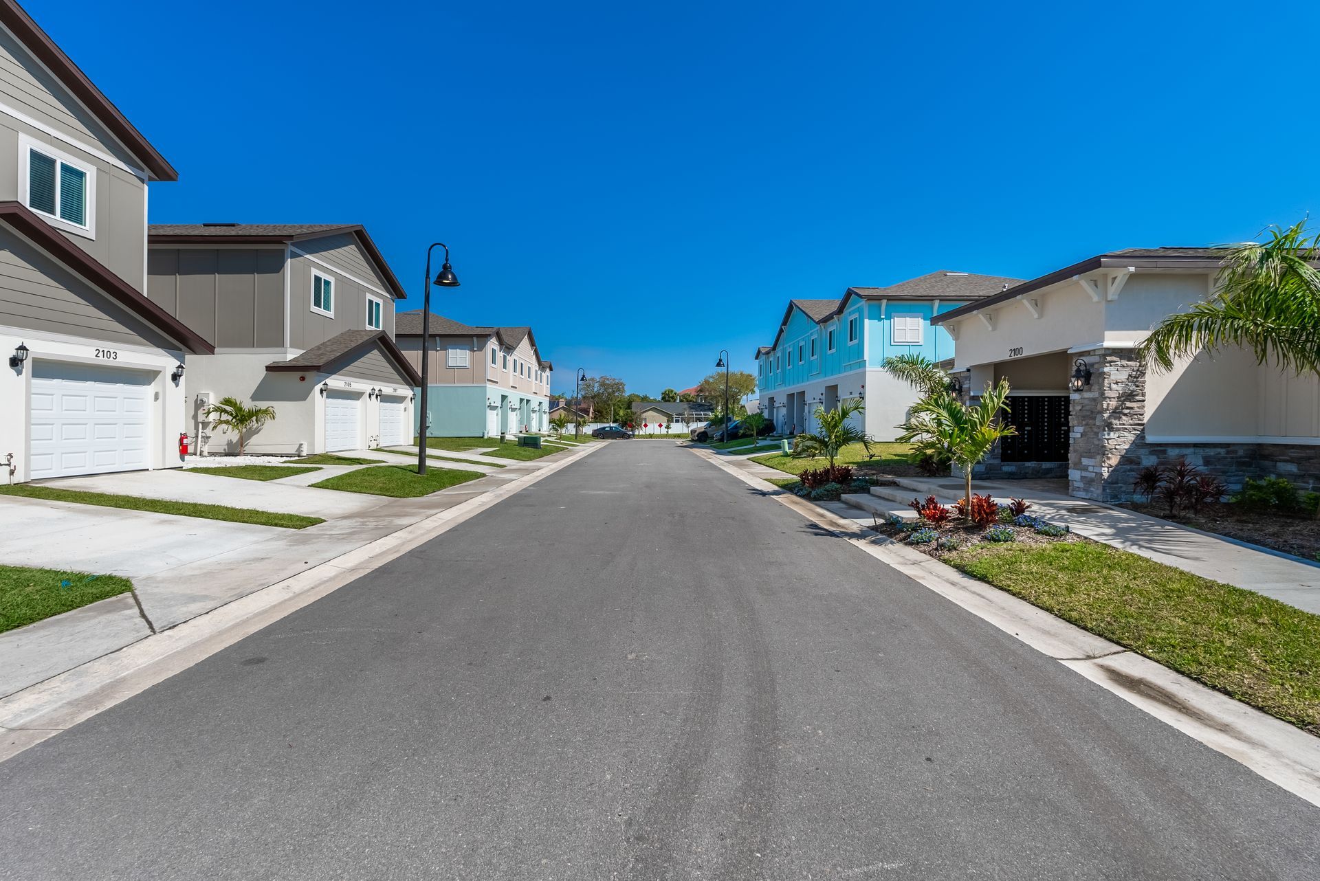a row of apartment town homes are lined up on the side of a street at Whitney Place Apartments in Clearwater, FL.