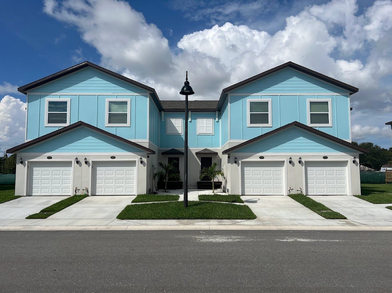a blue and white apartment with garage doors at Whitney Place Apartments in Clearwater, FL