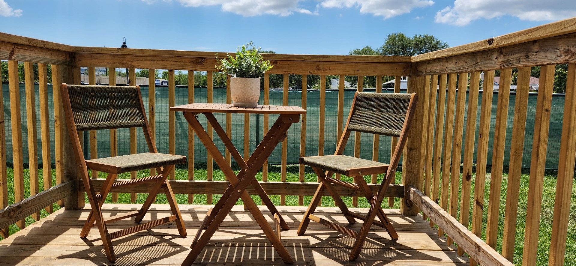 a wooden deck with a table and chairs on it at Whitney Place Apartments in Clearwater, FL.