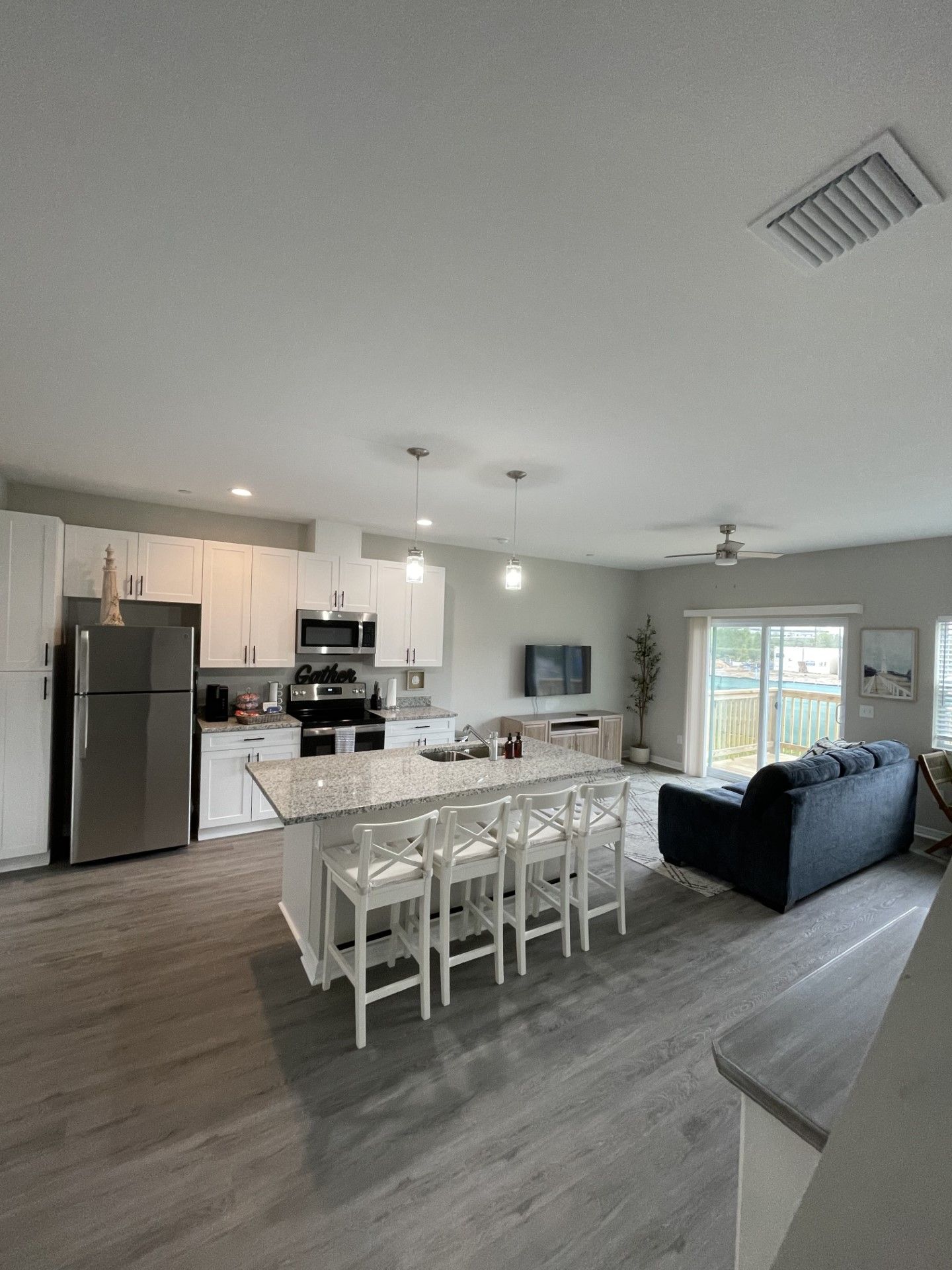 a living room with a kitchen and a couch at Whitney Place Apartments in Clearwater, FL