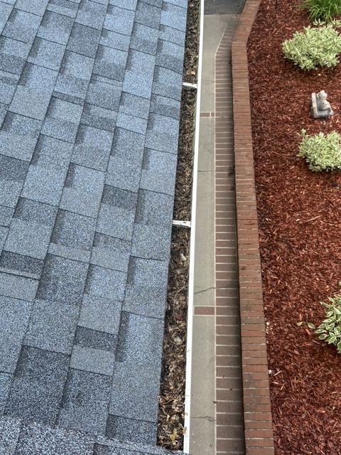 A close up of a gutter next to a roof.