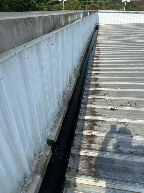 There is a drain on the side of the roof of a building.