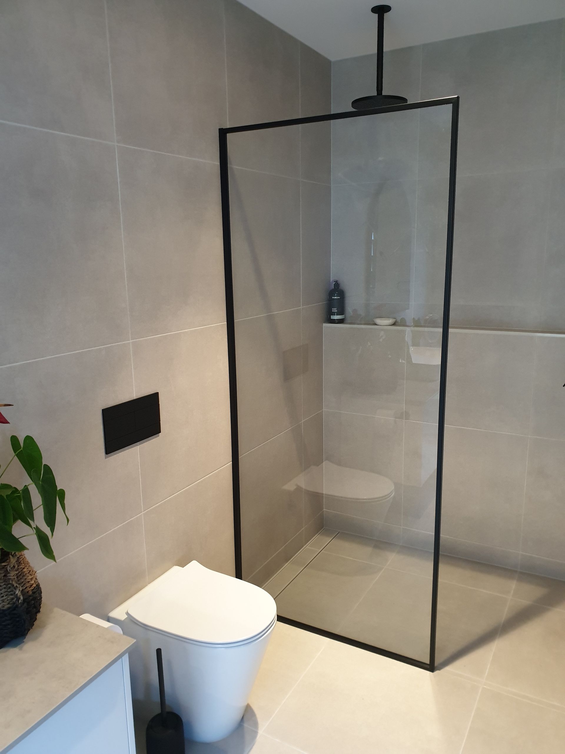 Bathroom With Grey Tiled Wall and Black Framed Shower — Local Glassmaster in Huskisson, NSW