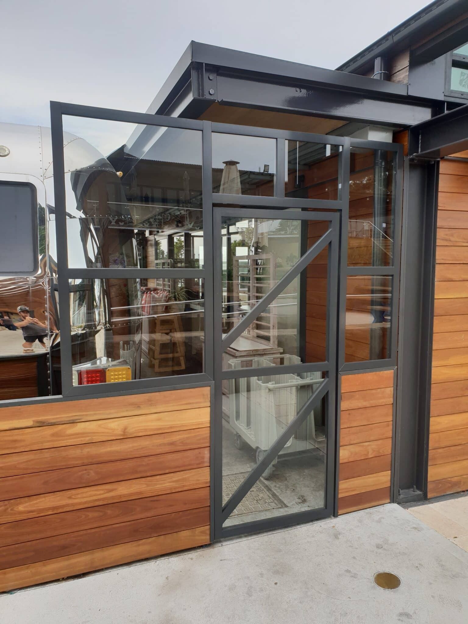 A Glass and Metal Door with A Window Attached — Local Glassmaster in Huskisson, NSW
