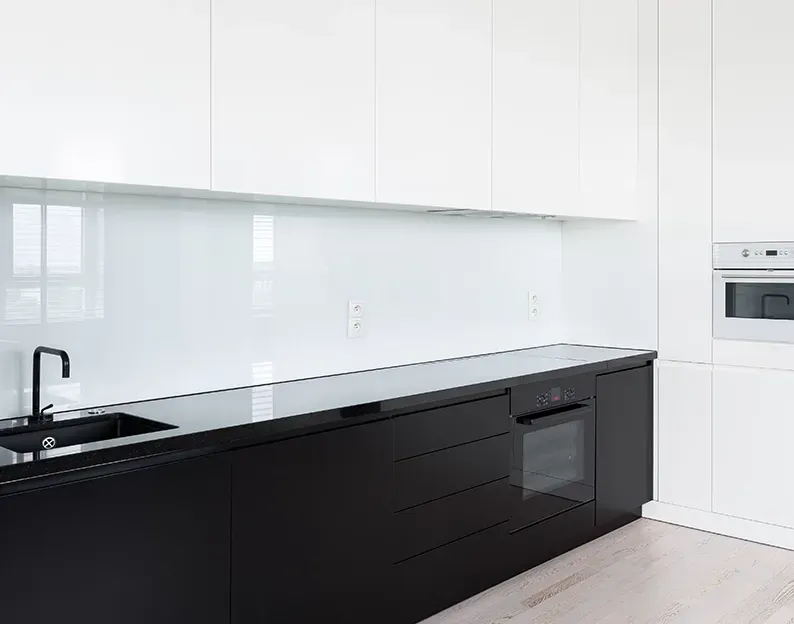 Kitchen With a Black Countertop With a White Glass Splashback — Local Glassmaster in Huskisson, NSW