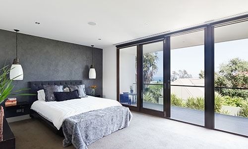 Modern Bedroom with Large Windows Overlooking Trees — Local Glassmaster in Huskisson, NSW