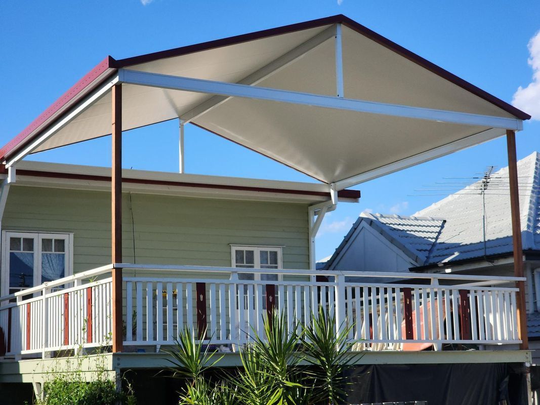 House with a white deck and awning; awning frame is brown and the roof is white.