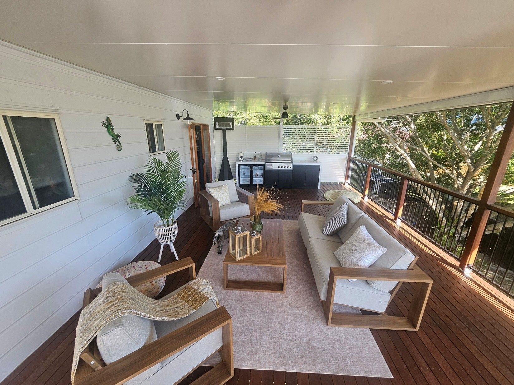 Outdoor deck with seating, grill, and plants.