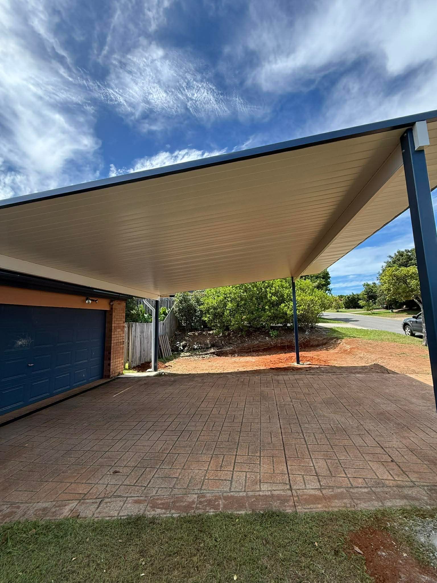 Wooden deck with tools and plants overlooking greenery.