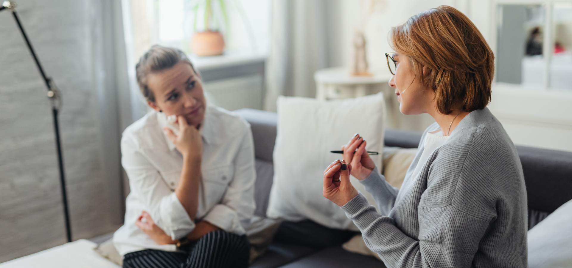 A therapist and a women sit across from each other in deep conversation.