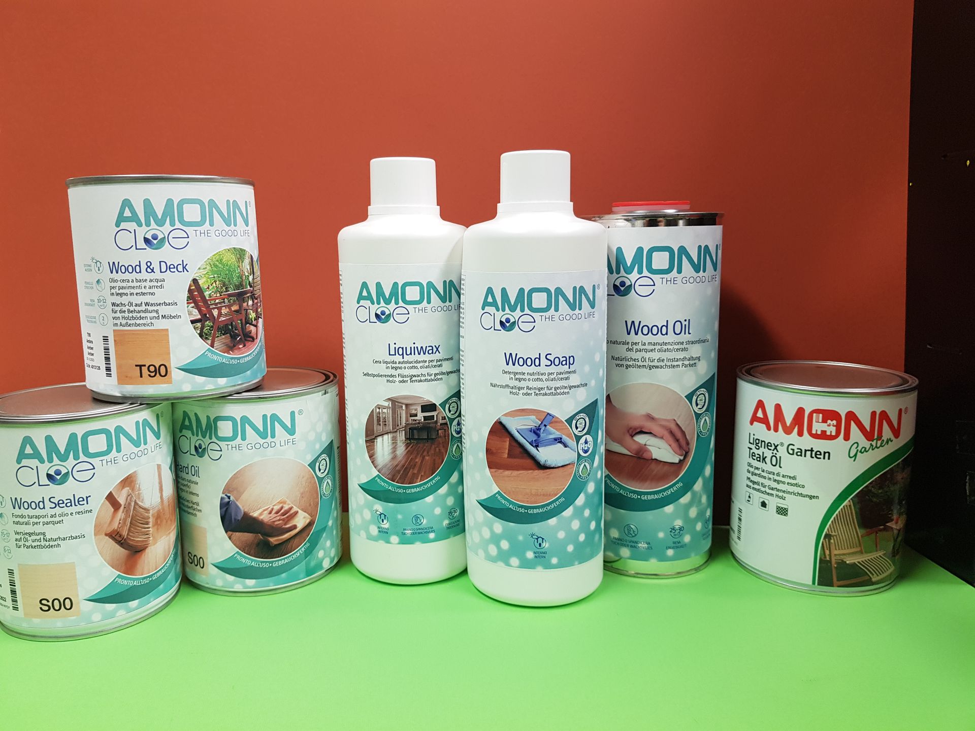 Pennello che applica vernice trasparente su una superficie di legno, primo piano.