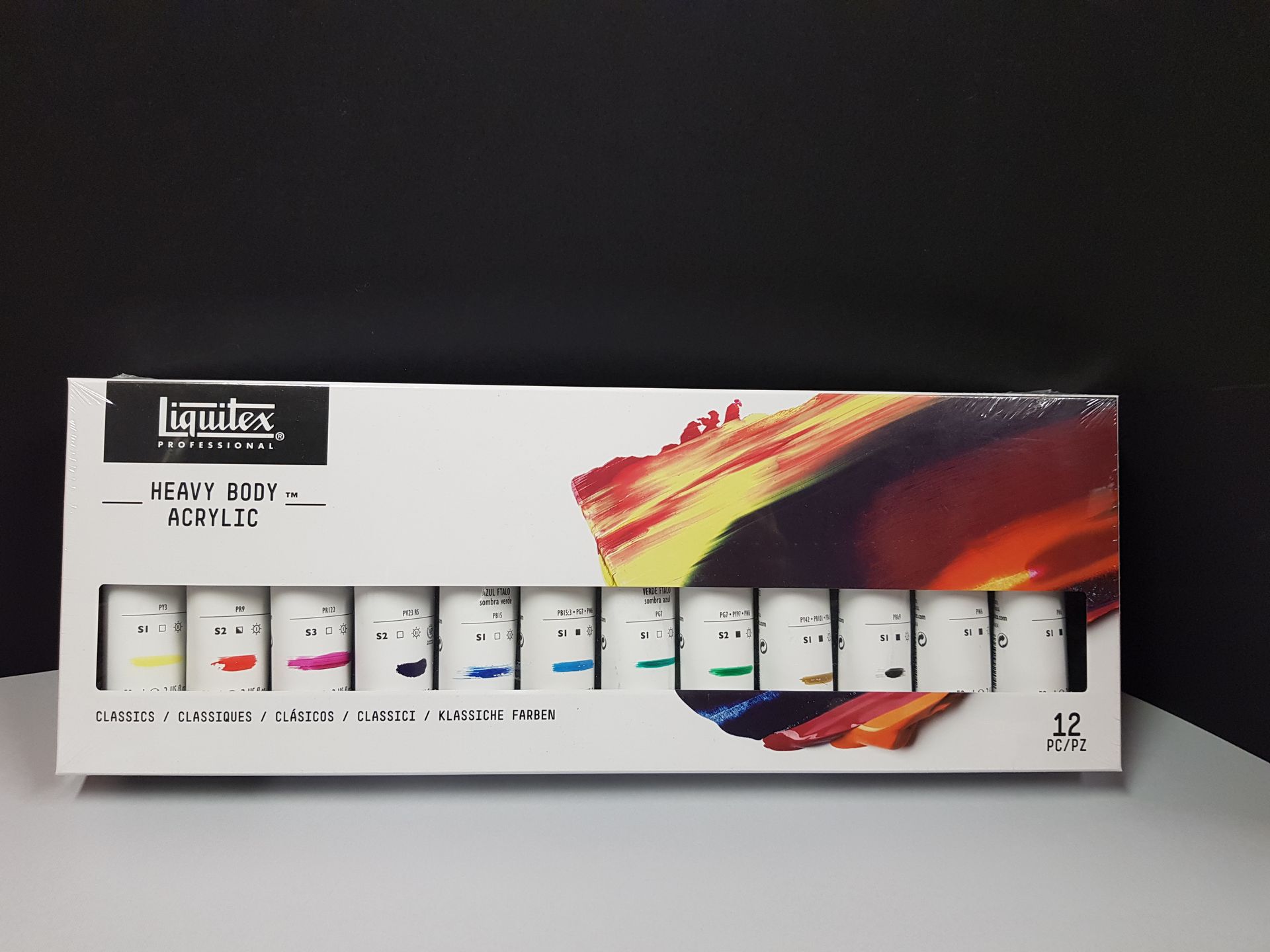 Scatola di tubetti di colori acrilici Liquitex Heavy Body, colori assortiti, su sfondo nero.
