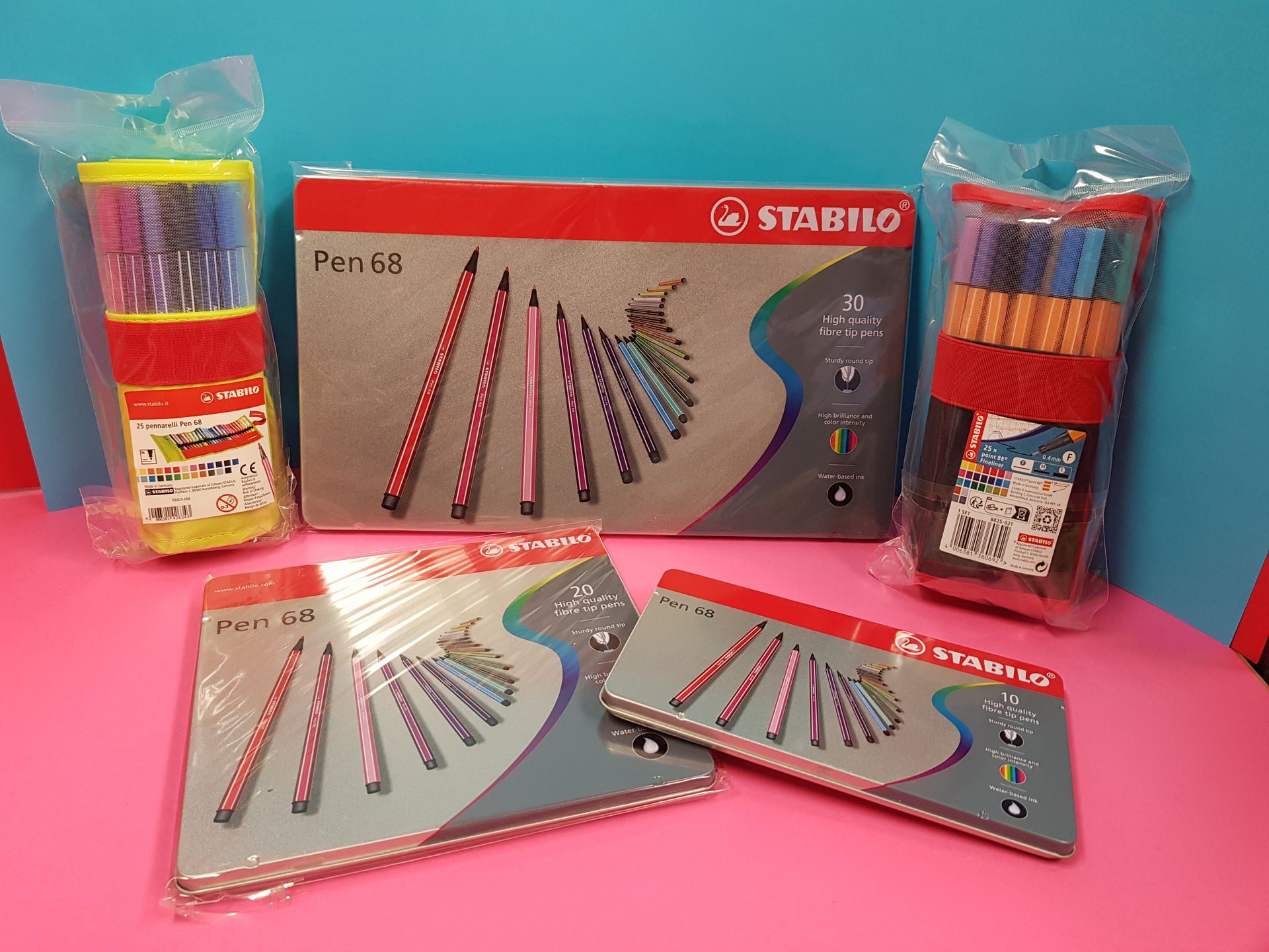 Assortimento di penne e pennarelli Stabilo in confezione su sfondo rosa e blu.