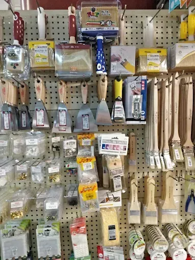 Scaffali che espongono attrezzi per la verniciatura e ferramenta in un negozio.