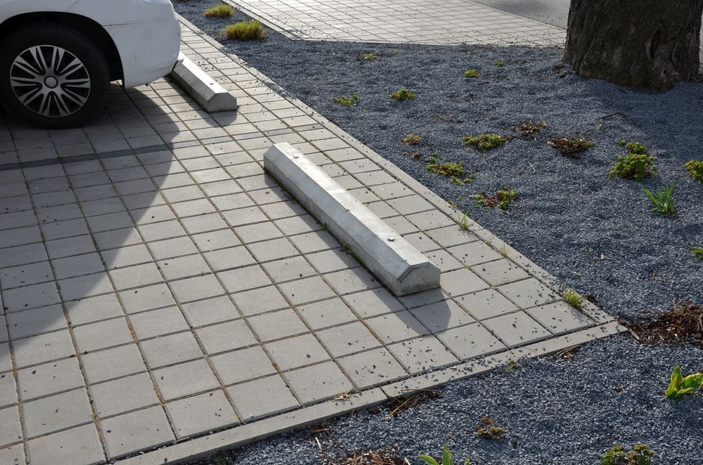 A row of yellow parking blocks on the side of a road.