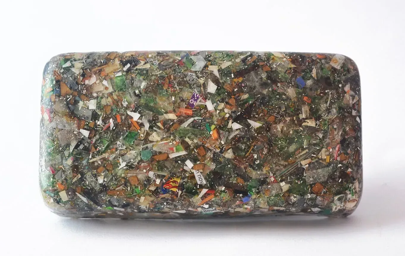 Losa rectangular de agregado de vidrio reciclado multicolor sobre un fondo blanco.