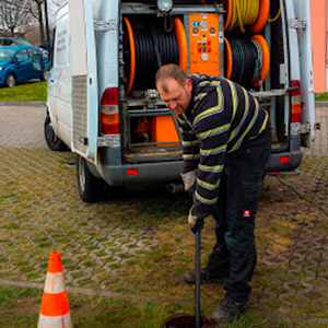Ein Mann gräbt vor einem Lieferwagen ein Loch in den Boden