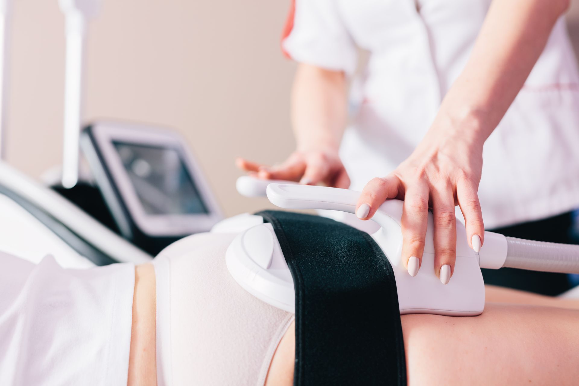 A woman is getting a treatment on her stomach in a beauty salon.