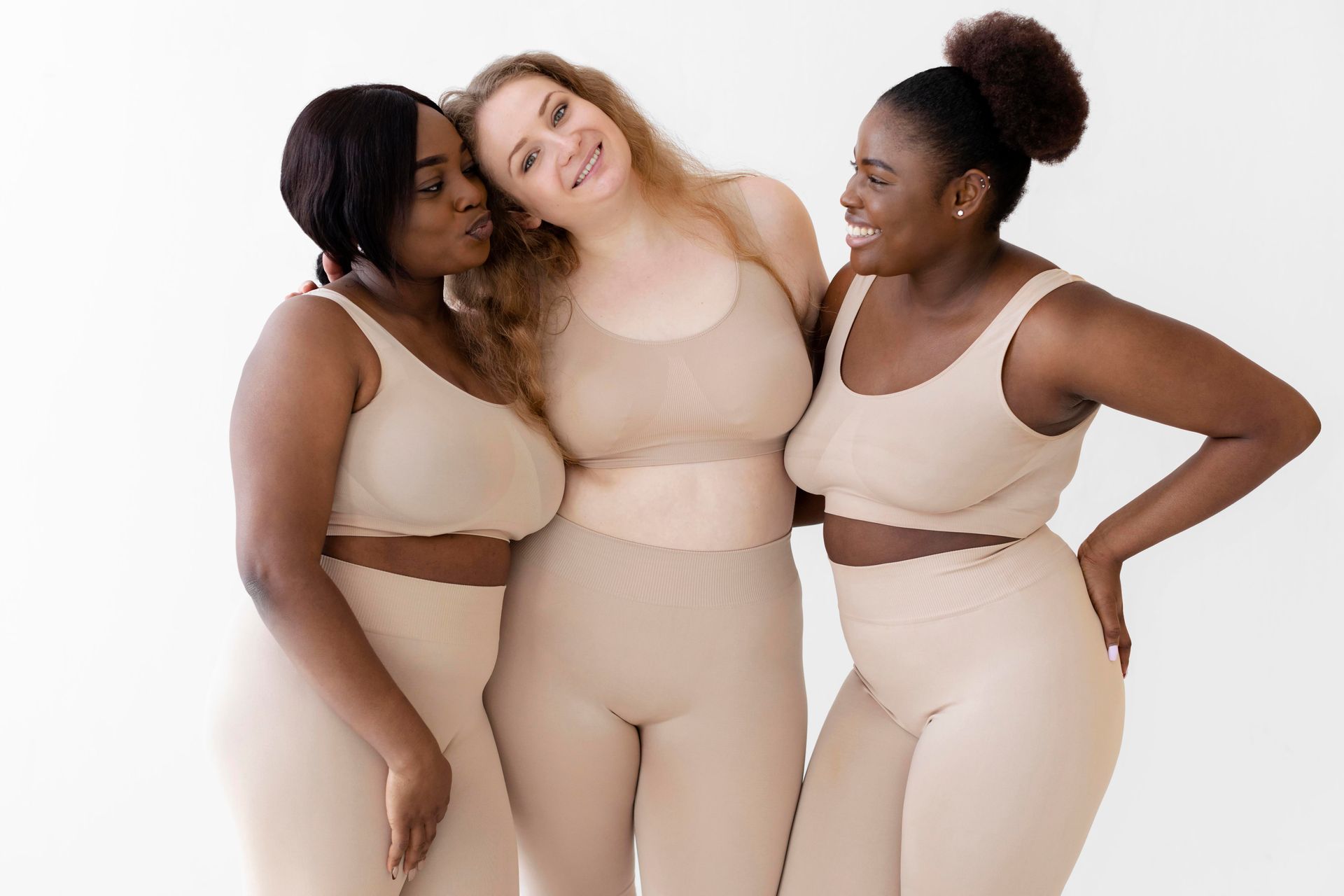 Three women of different races are posing for a picture together.