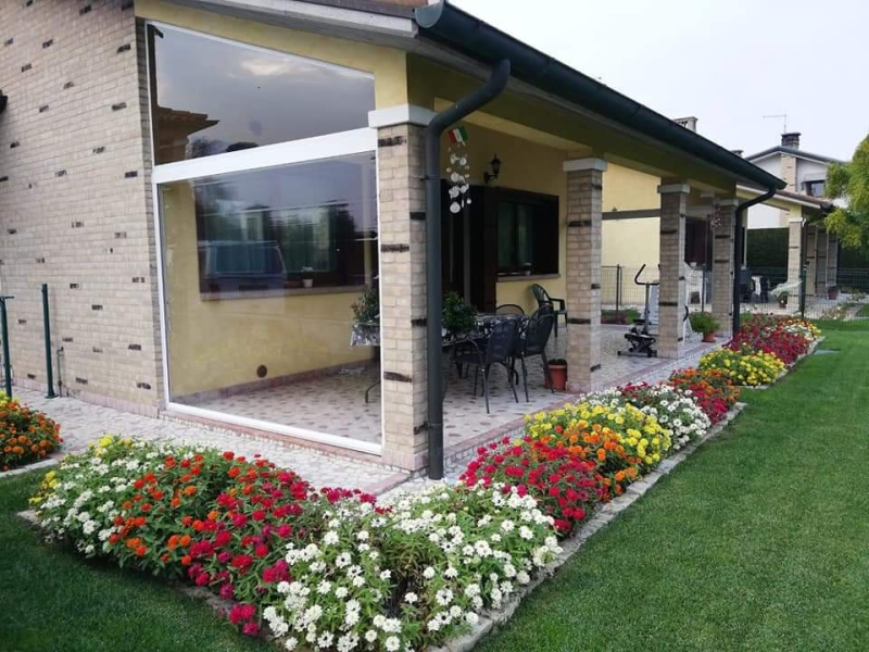 Una casa con un patio e dei fiori davanti