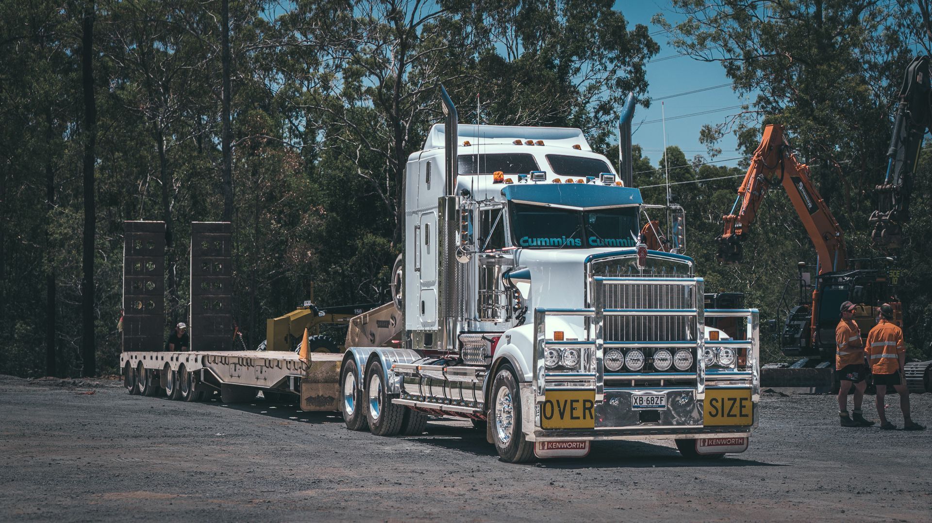 A large spencer civil & earthworks excavator is sitting on top of a truck. A great example of our haulage services.