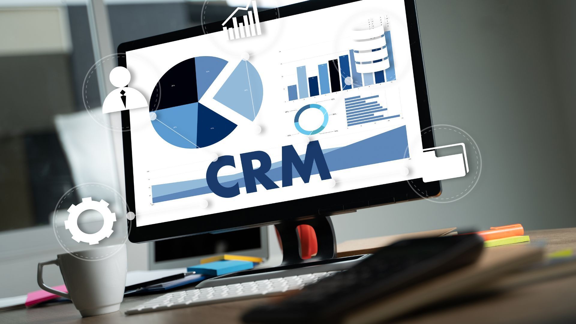 A computer monitor with the word crm on it is sitting on a desk.
