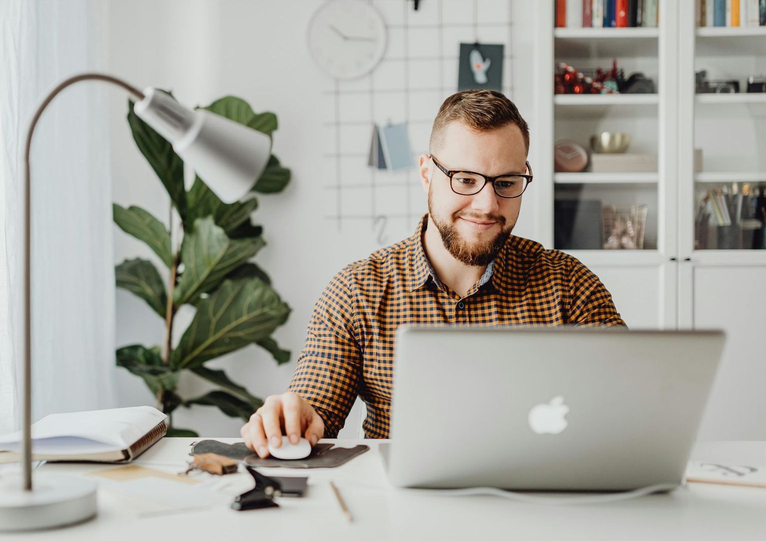 A man is sitting at a desk using a laptop computer.