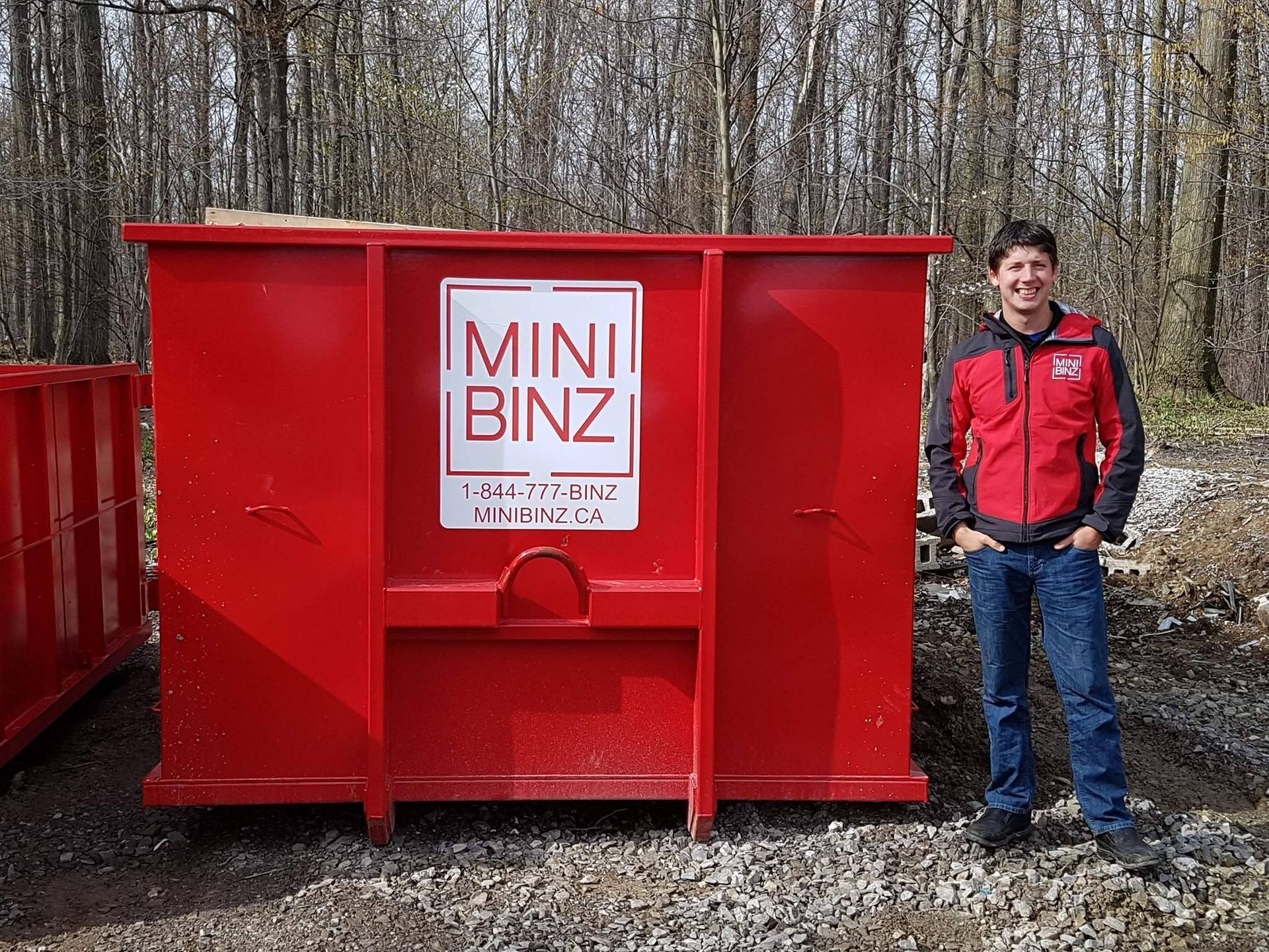 A man stands beside a large red 