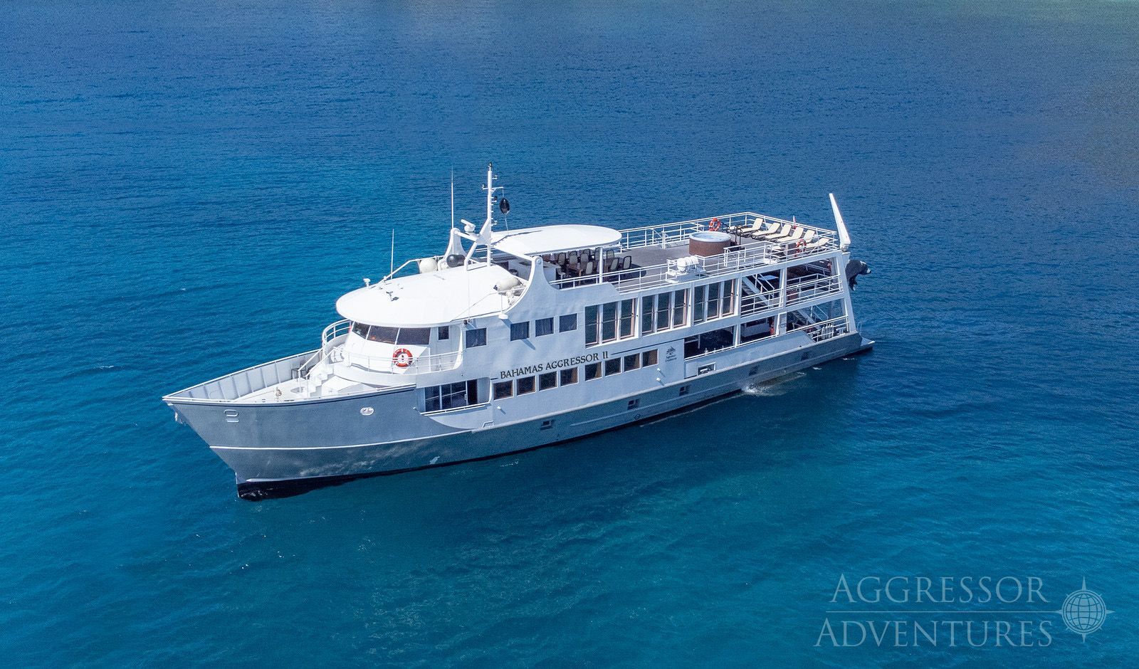 Bedroom with wooden furniture, four-poster bed with mosquito net, straw roof and woven walls.