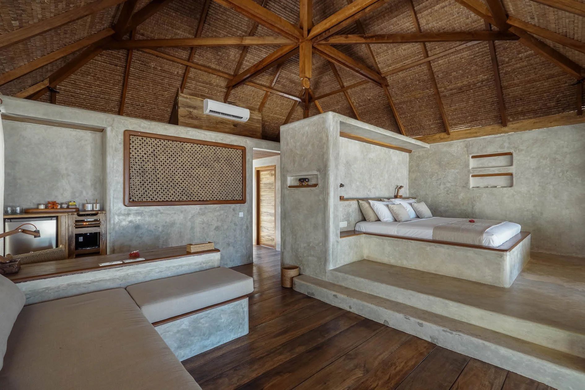 Harlequin shrimp with white body, blue spots, and feathery claws on a dark surface.