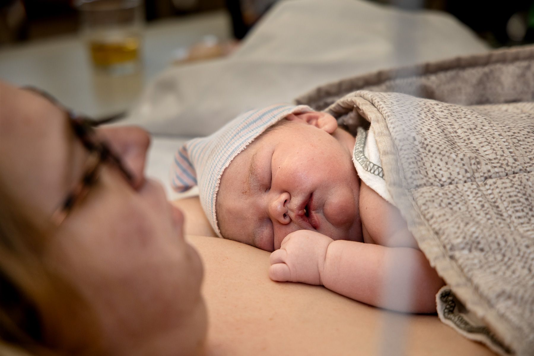Pasgeboren baby ligt huid op huid bij moeder na de geboorte